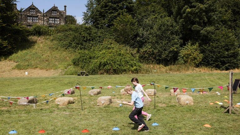 Children playing sports games on the lower fields at East Riddlesden Hall, Yorkshire